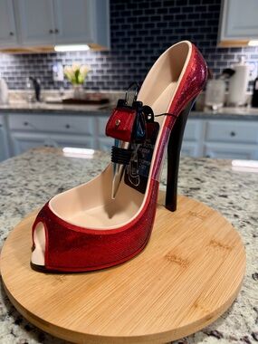Decorative, Open-toe, backless high-heeled shoe designed to hold a wine bottle.